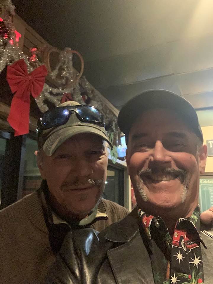 Two men with mustaches celebrating at a pub Christmas party