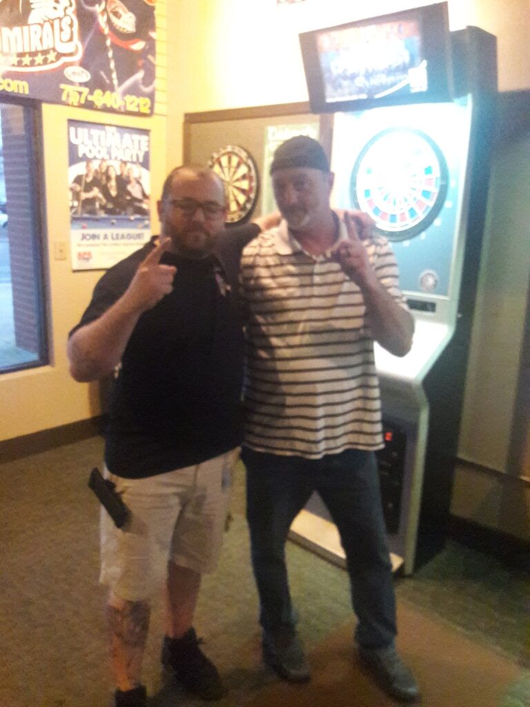 First place in doubles dart tournament holding up their fingers as number 1