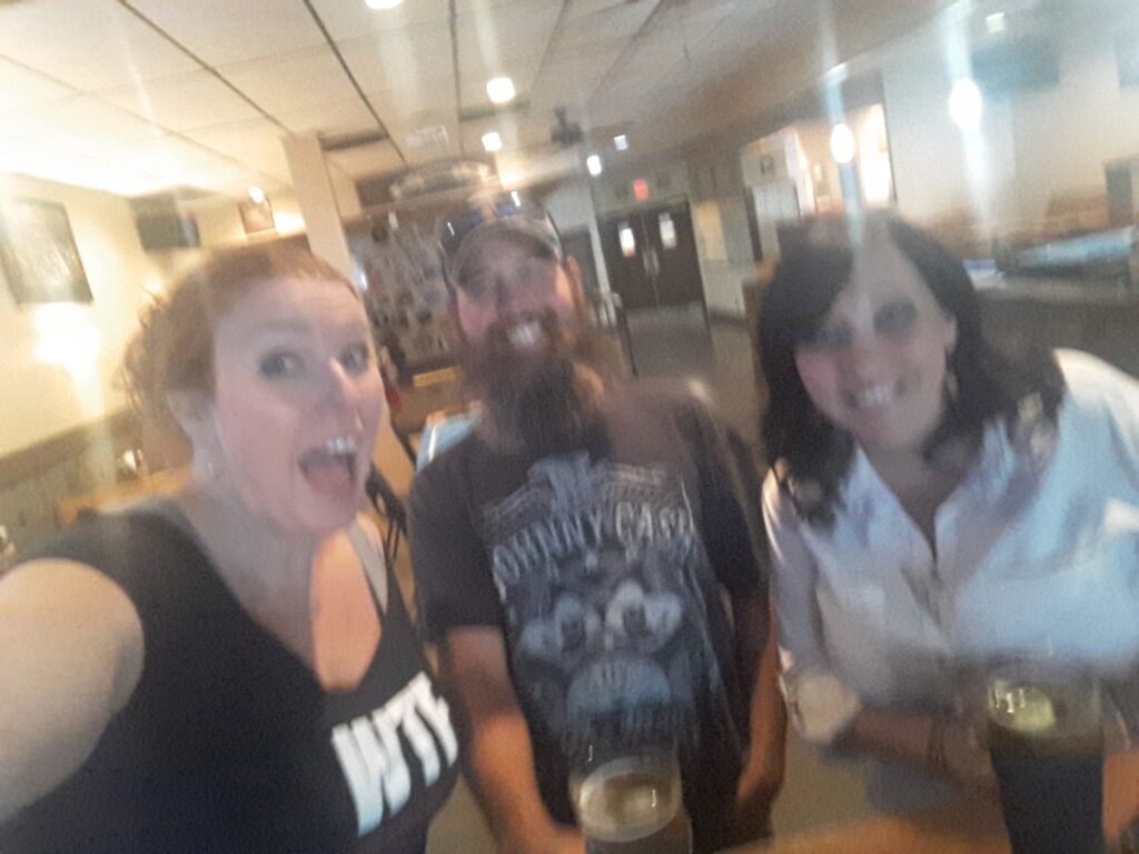 Fuzzy photo of Tish, Josh and Denae grinning for the camera at the pub